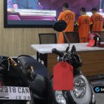 Foto : barang bukti yang disita dua unit sepeda motor (Honda Beat dan Honda Scoopy) serta kunci T modifikasi yang disusun rapi di depan latar logo Polres Lamongan.