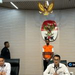 Foto : Pelaksana Tugas Deputi KPK Asep Guntur Rahayu (kiri) dan Juru Bicara KPK Budi Prasetyo (kanan) berdiri di depan logo KPK dalam konferensi pers pengumuman tersangka di Gedung Merah Putih KPK.