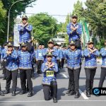 Foto : Suasana semangat peserta gerak jalan saat melintasi Jalan Dr. Wahidin atau Jalan Basuki Rahmat dengan seragam regu yang berwarna-warni.