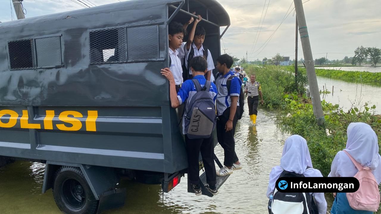 Foto : Kendaraan dinas Polres Lamongan (mobil patrolidouble cabin) melintasi jalan yang tergenang air dengan beberapa siswa di dalamnya.