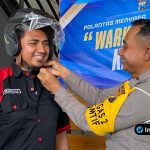 Foto : Personel Satlantas menyerahkan bantuan helm SNI dan paket beras secara simbolis kepada perwakilan driver ojol.
